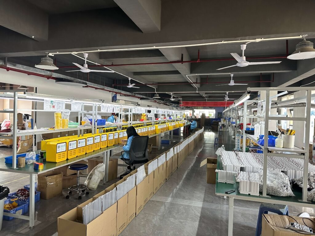 Modern power bank production facility with organized workstations featuring yellow storage bins and quality control checkpoints